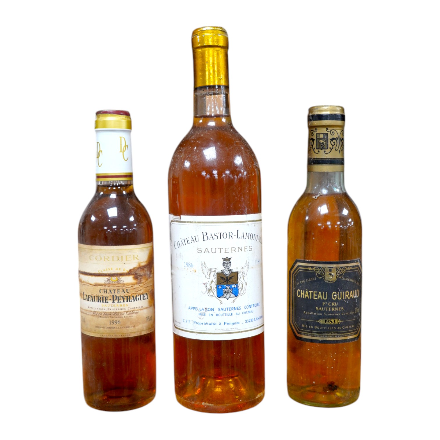 Wine: a bottle of French Sauternes and two half bottles comprising a bottle of Chateau Bastor - Lamontagne 1986, a half bottle of Chateau Guiraud Ist Cru 1983 with another half bottle of Chateau Lafaurie - Peyraguey 1996